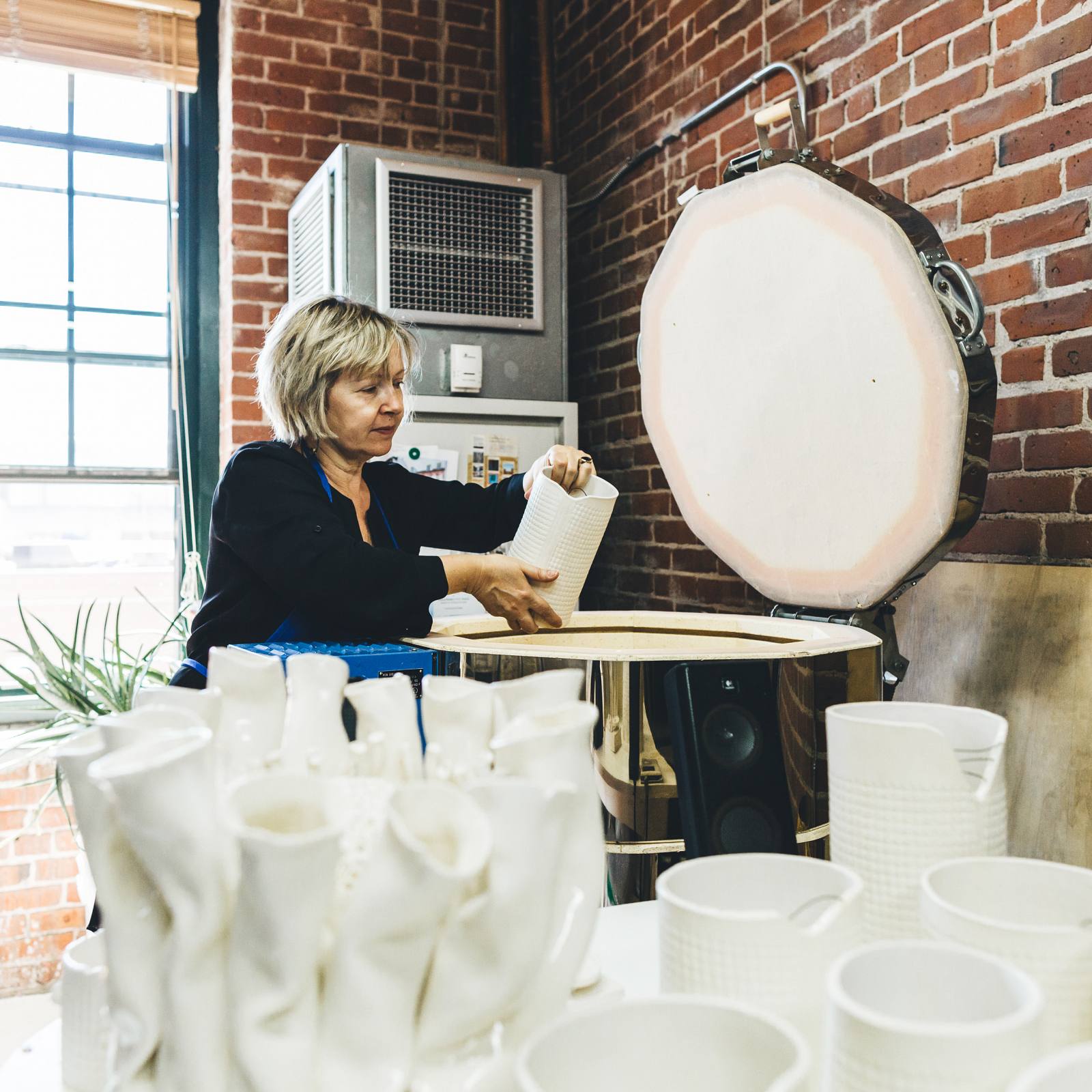 Liliana loading her kiln with ceramic pieces.